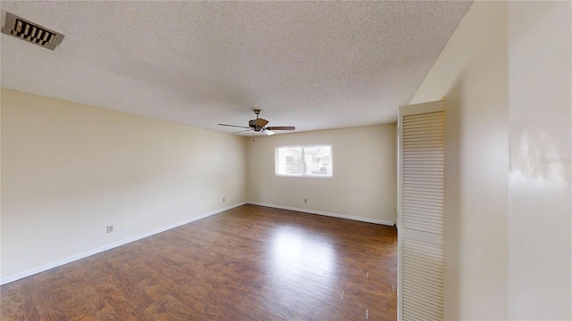 spare room featuring a textured ceiling, ceiling fan, wood finished floors, and baseboards