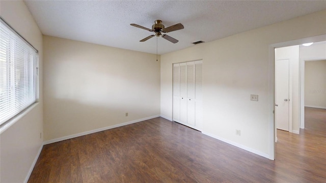 unfurnished bedroom featuring wood finished floors, a closet, and baseboards