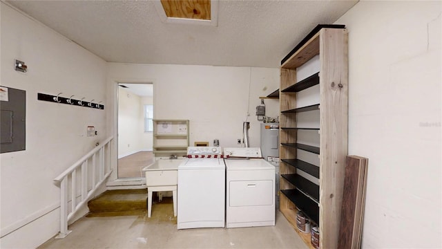 laundry room with washing machine and clothes dryer, electric water heater, electric panel, and a textured ceiling