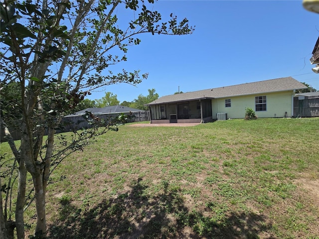 view of yard with a sunroom and central AC unit