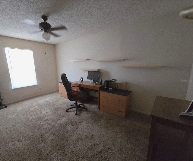 carpeted home office with a ceiling fan and a textured ceiling