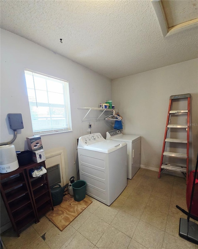 clothes washing area featuring washing machine and dryer and a textured ceiling