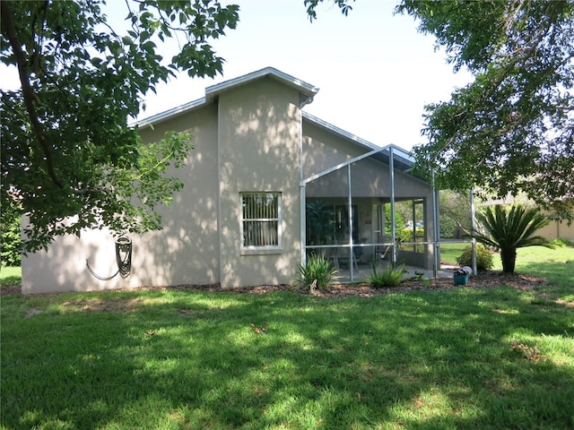 1799 W Shanelle Path, Lecanto, FL 34461 - back of property featuring a lawn, stucco siding, and a sunroom