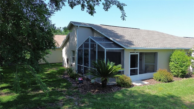 1799 W Shanelle Path, Lecanto, FL 34461 - back of property featuring stucco siding, a sunroom, roof with shingles, and a lawn