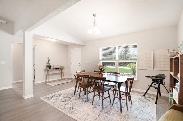 13561 SW 85th Pl, Dunnellon, FL 34432 - dining space with lofted ceiling, wood finished floors, baseboards, and a chandelier