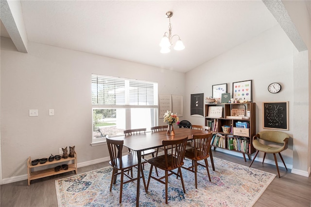 13561 SW 85th Pl, Dunnellon, FL 34432 - dining area featuring a chandelier, baseboards, light wood finished floors, and vaulted ceiling