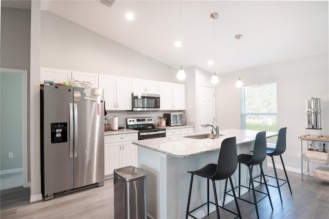 13561 SW 85th Pl, Dunnellon, FL 34432 - kitchen with appliances with stainless steel finishes, a sink, white cabinets, a kitchen breakfast bar, and light wood-type flooring