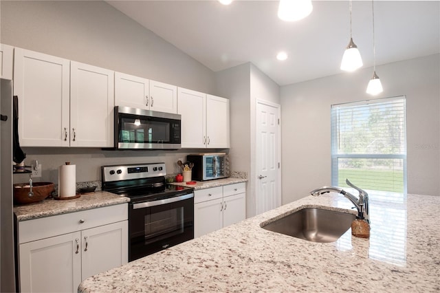 13561 SW 85th Pl, Dunnellon, FL 34432 - kitchen with appliances with stainless steel finishes, a sink, white cabinets, hanging light fixtures, and vaulted ceiling