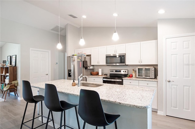 13561 SW 85th Pl, Dunnellon, FL 34432 - kitchen featuring stainless steel appliances, a sink, high vaulted ceiling, a kitchen breakfast bar, and an island with sink