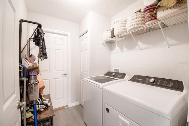 13561 SW 85th Pl, Dunnellon, FL 34432 - washroom with washer and clothes dryer, light wood-style flooring, a textured ceiling, and baseboards