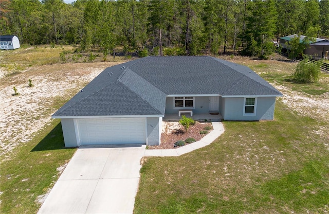 13561 SW 85th Pl, Dunnellon, FL 34432 - view of front facade with a garage, a front lawn, driveway, a shingled roof, and stucco siding