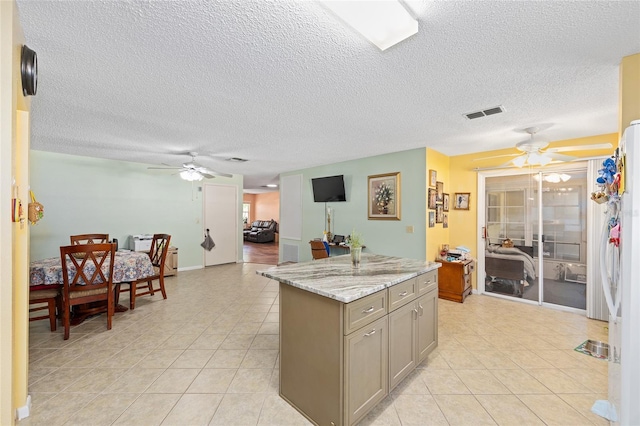 9661 SW 95th Ct Unit B, Ocala, FL 34481 - kitchen featuring ceiling fan, light tile patterned flooring, gray cabinetry, a textured ceiling, and a kitchen island