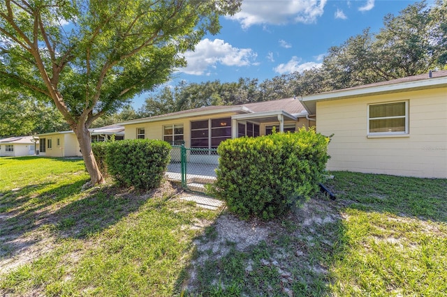 9661 SW 95th Ct Unit B, Ocala, FL 34481 - rear view of property with a lawn and a sunroom