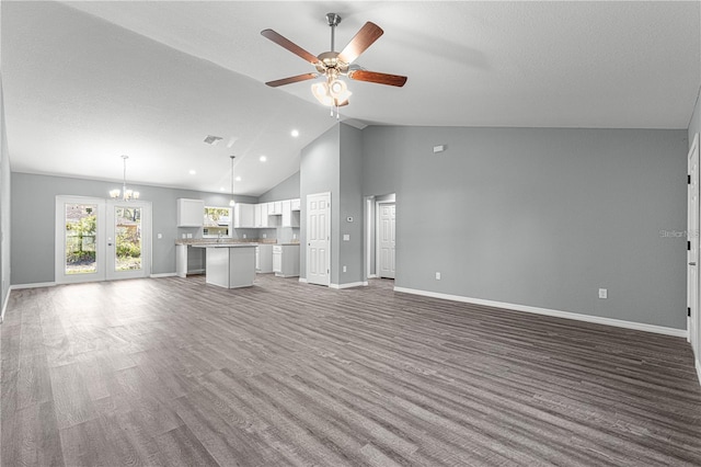 unfurnished living room featuring ceiling fan, baseboards, a chandelier, high vaulted ceiling, and wood finished floors