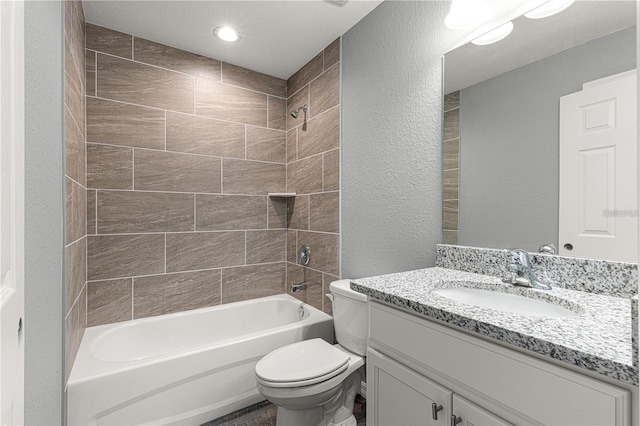 bathroom featuring shower / bathtub combination, toilet, vanity, and a textured wall