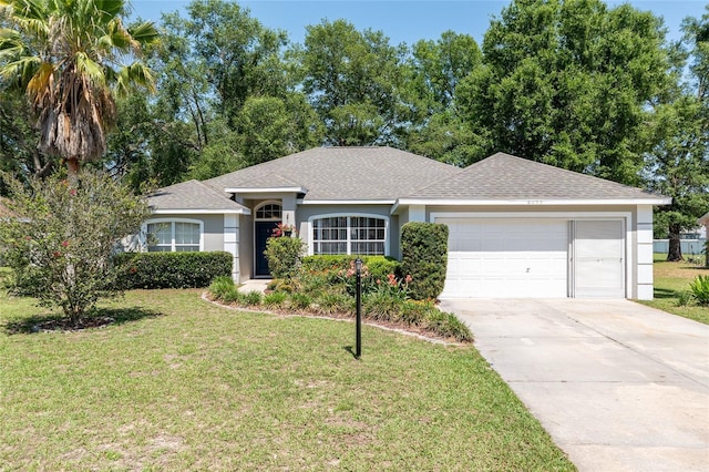 8053 SW 62nd Ave, Ocala, FL 34476 - ranch-style house featuring an attached garage, a shingled roof, driveway, a front yard, and stucco siding