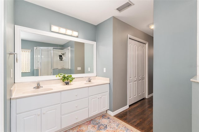 8053 SW 62nd Ave, Ocala, FL 34476 - bathroom with a stall shower, wood finished floors, double vanity, and baseboards