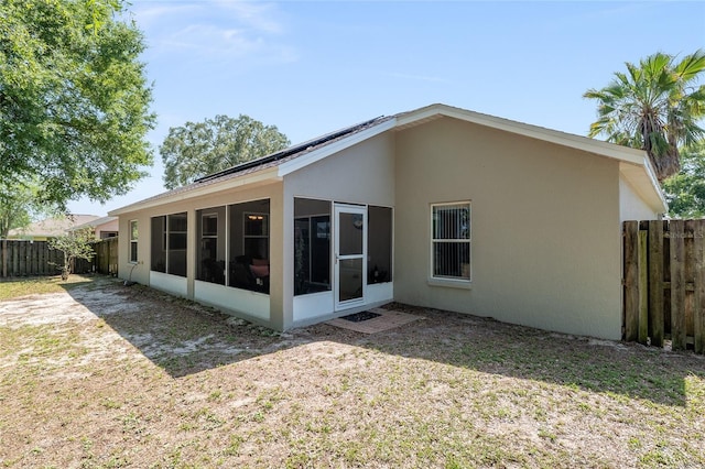 8053 SW 62nd Ave, Ocala, FL 34476 - back of house with stucco siding, a fenced backyard, and a sunroom