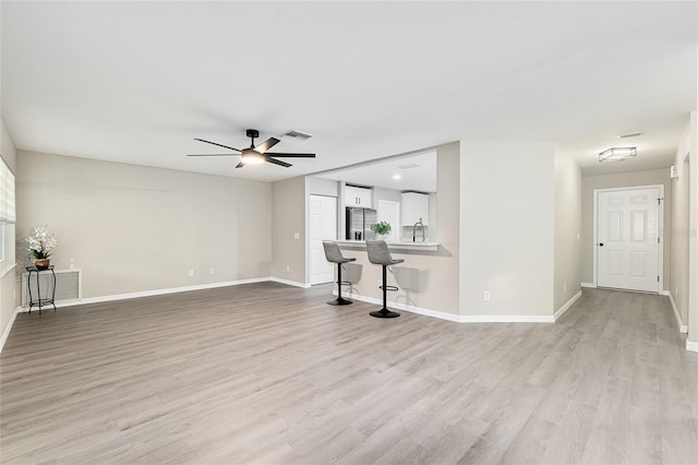 9729 SW 97th St, Ocala, FL 34481 - unfurnished living room featuring ceiling fan, light wood finished floors, and baseboards