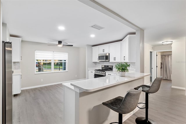 9729 SW 97th St, Ocala, FL 34481 - kitchen with appliances with stainless steel finishes, decorative backsplash, and light wood finished floors