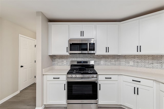 9729 SW 97th St, Ocala, FL 34481 - kitchen featuring stainless steel appliances, wood finished floors, decorative backsplash, baseboards, and white cabinetry