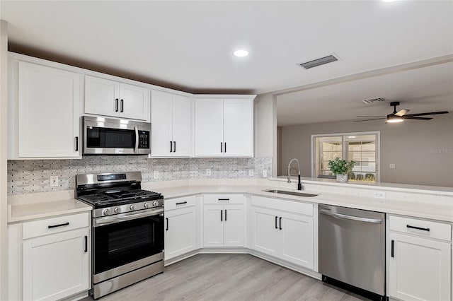 9729 SW 97th St, Ocala, FL 34481 - kitchen with stainless steel appliances, a sink, light countertops, ceiling fan, and decorative backsplash