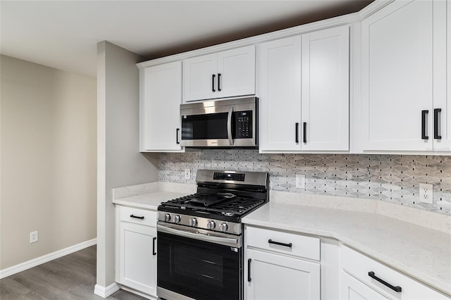 9729 SW 97th St, Ocala, FL 34481 - kitchen with stainless steel appliances, baseboards, wood finished floors, decorative backsplash, and white cabinetry