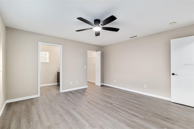 9729 SW 97th St, Ocala, FL 34481 - unfurnished bedroom with a walk in closet, light wood-type flooring, baseboards, and a ceiling fan