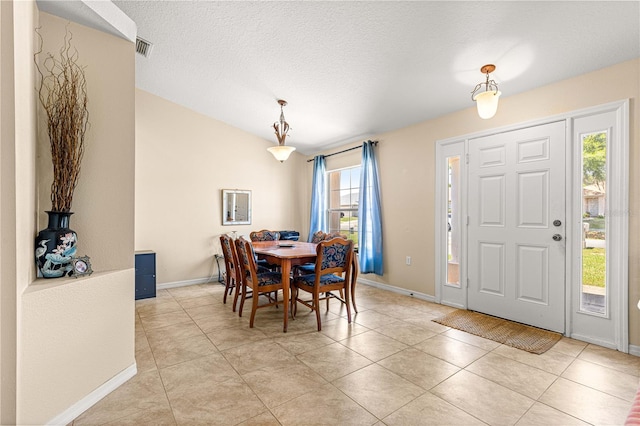 dining area with baseboards, light tile patterned floors, and a textured ceiling