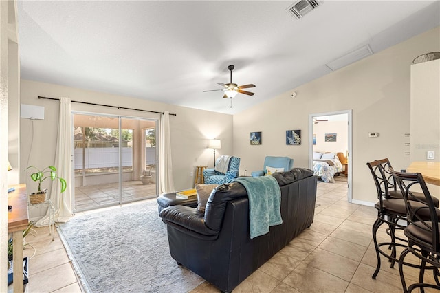 living area featuring lofted ceiling, light tile patterned floors, and ceiling fan