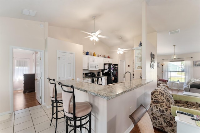 5920 SW 88th Pl, Ocala, FL 34476 - kitchen featuring black appliances, ceiling fan, a kitchen bar, light countertops, and a peninsula