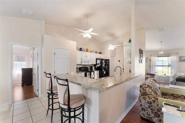 5920 SW 88th Pl, Ocala, FL 34476 - kitchen with black appliances, ceiling fan, a breakfast bar, light countertops, and a sink