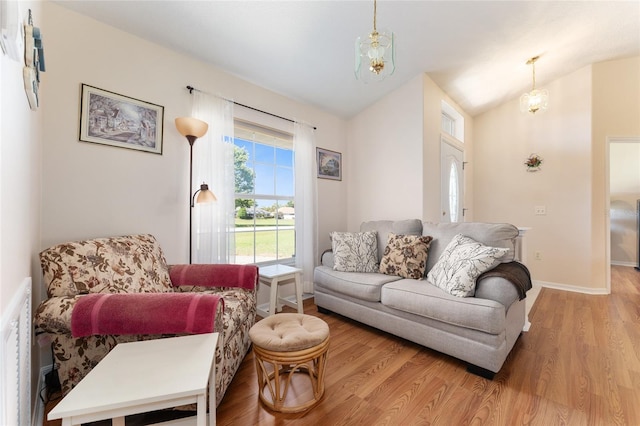 5920 SW 88th Pl, Ocala, FL 34476 - living room featuring light wood-type flooring, vaulted ceiling, baseboards, and a chandelier