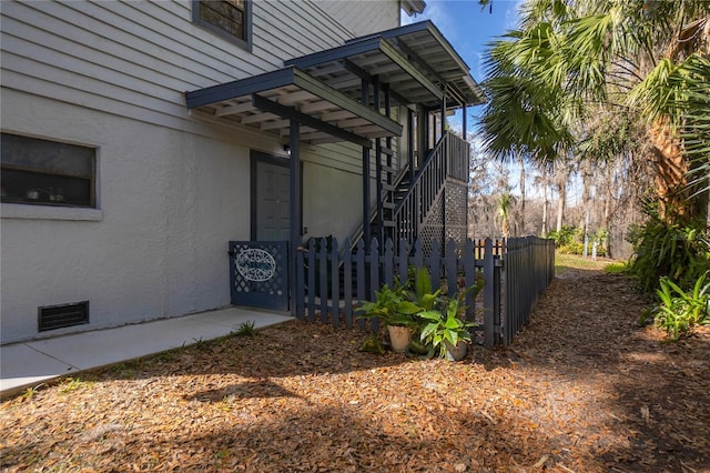 6620 S Merleing Loop, Floral City, FL 34436 - view of side of property with fence, stairway, stucco siding, and crawl space
