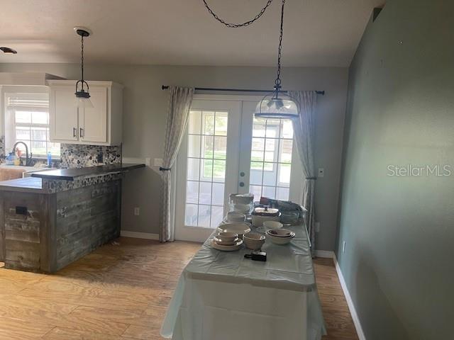6051 NE 25th Ave, Ocala, FL 34479 - dining area with light wood-style floors, baseboards, and french doors
