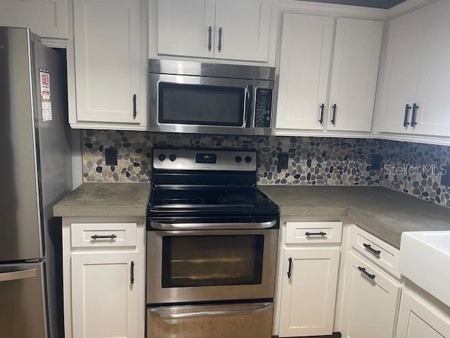 6051 NE 25th Ave, Ocala, FL 34479 - kitchen with stainless steel appliances, tasteful backsplash, and white cabinets
