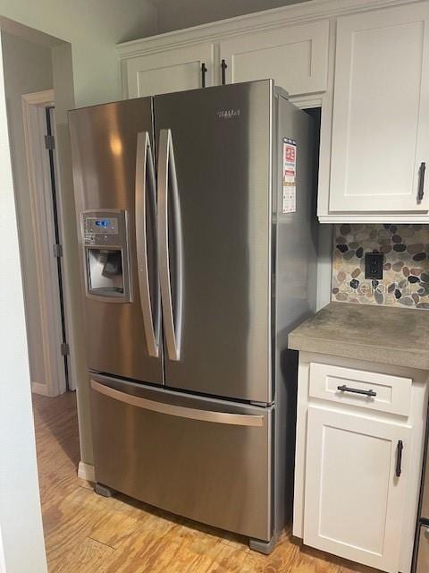 6051 NE 25th Ave, Ocala, FL 34479 - kitchen with stainless steel fridge with ice dispenser, white cabinetry, light wood finished floors, and tasteful backsplash