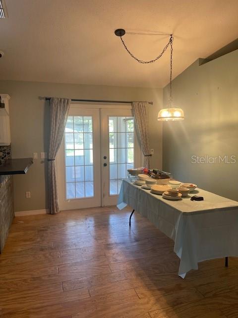 6051 NE 25th Ave, Ocala, FL 34479 - dining room featuring wood finished floors, french doors, baseboards, and vaulted ceiling