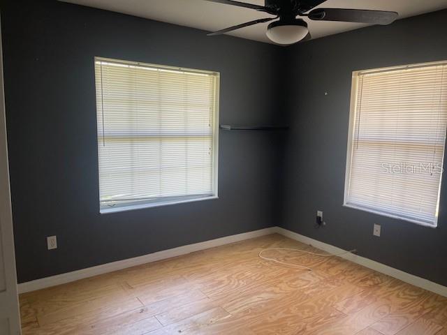 6051 NE 25th Ave, Ocala, FL 34479 - empty room with a ceiling fan, light wood-style flooring, and baseboards