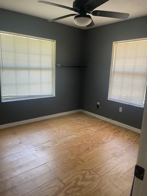 6051 NE 25th Ave, Ocala, FL 34479 - empty room featuring ceiling fan, wood finished floors, and baseboards