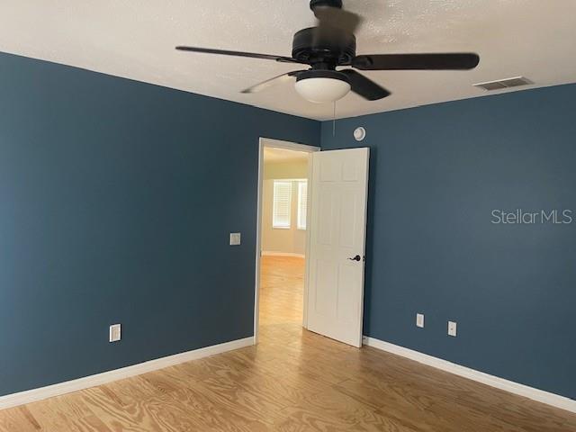 6051 NE 25th Ave, Ocala, FL 34479 - spare room featuring a ceiling fan, wood finished floors, and baseboards