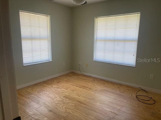 6051 NE 25th Ave, Ocala, FL 34479 - empty room with light wood finished floors, baseboards, and a ceiling fan