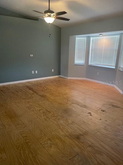 6051 NE 25th Ave, Ocala, FL 34479 - spare room featuring hardwood / wood-style flooring, a ceiling fan, and baseboards