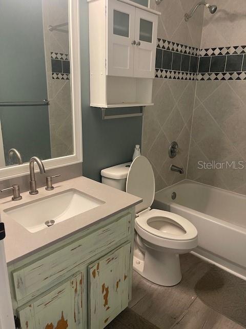6051 NE 25th Ave, Ocala, FL 34479 - bathroom featuring shower / bath combination, toilet, vanity, and wood finished floors