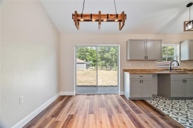 5193 NW 61st Ave, Ocala, FL 34482 - kitchen featuring a sink, gray cabinetry, baseboards, light wood finished floors, and lofted ceiling