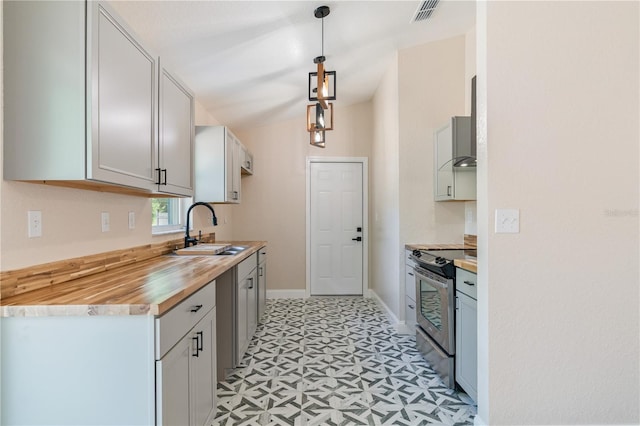 5193 NW 61st Ave, Ocala, FL 34482 - kitchen with stainless steel range with electric stovetop, a sink, light floors, vaulted ceiling, and baseboards