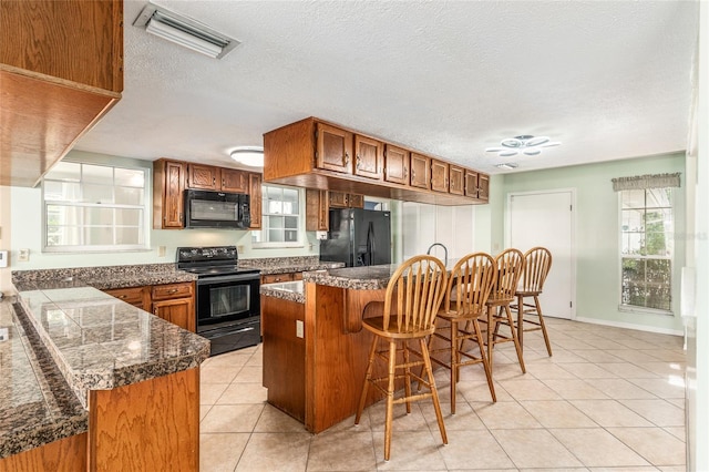 1404 SE 40th Ct, Ocala, FL 34471 - kitchen with black appliances, brown cabinets, light tile patterned floors, tile countertops, and a textured ceiling