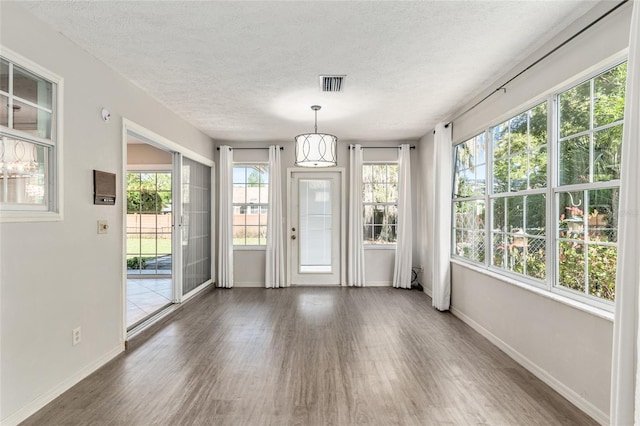 1404 SE 40th Ct, Ocala, FL 34471 - unfurnished sunroom with wood finished floors, a textured ceiling, and baseboards