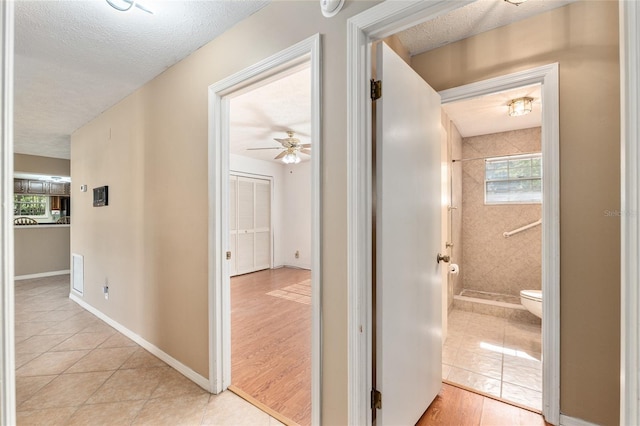 1404 SE 40th Ct, Ocala, FL 34471 - hall featuring a textured ceiling, light tile patterned flooring, and baseboards