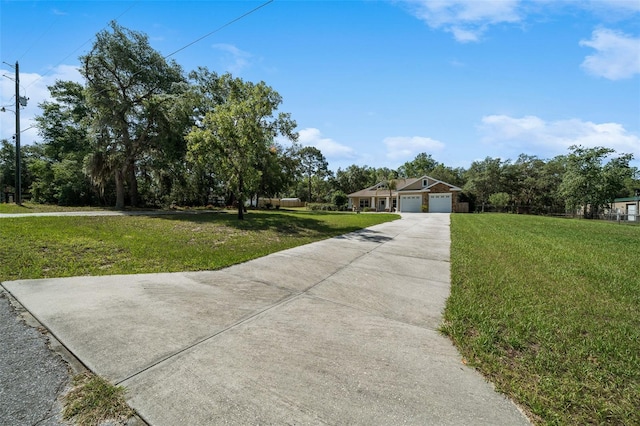 2948 W Henley Ln, Dunnellon, FL 34433 - view of front facade with a front yard, concrete driveway, and a garage